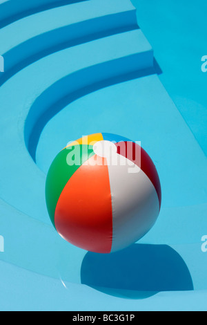 Beachball floating in a still swimming pool Stock Photo