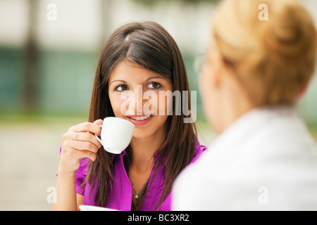 two business women drinking coffee outdoors Stock Photo
