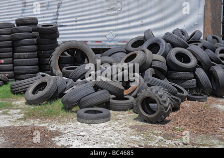 A pile of worn used tires sits in back of  an auto repair shop, Florida. Stock Photo