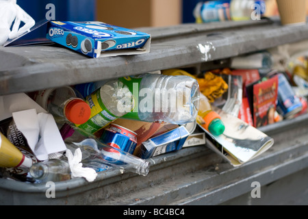 A garbage bin overflows in the street. Stock Photo