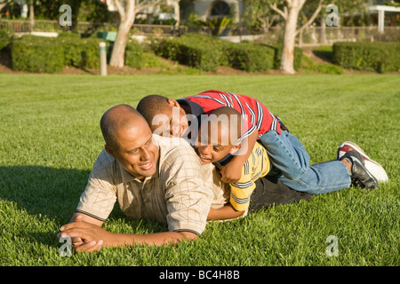 California dad boys African-American parent and sons enjoy wrestling and piling on tumbling with each other outside. MR  © Myrleen Pearson Stock Photo