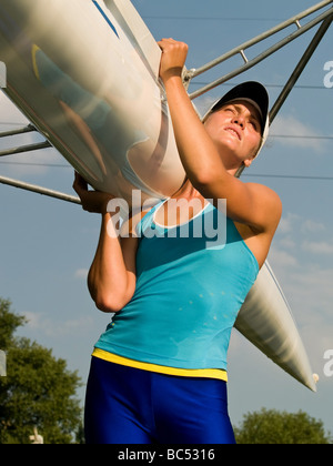 Rower girl holding boat outdoors Stock Photo