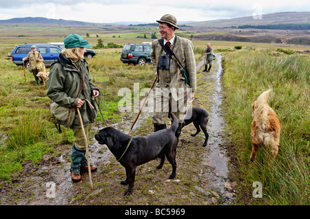 Dog Handler and Gamekeeper Talking on Moor after a Driven Red Grouse SHoot in the Highlands in Scotland Stock Photo