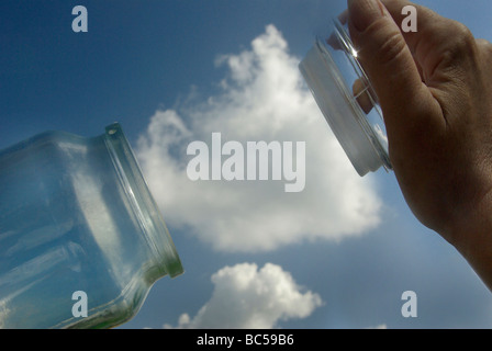 Carbon capture concept depicing a cloud (CO2) being trapped into a jar (storage) Stock Photo