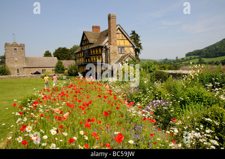 Stokesay Castle gatehouse wild flowers growing in the courtyard and John the Baptist Church Shropshire England UK
