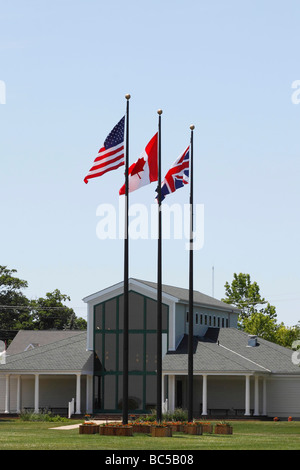 Put in Bay Ohio USA United States flags USA British Canadian on a pole against blue sky background in Ohio US daily life living lifestyle hi-res Stock Photo