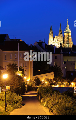 PRAGUE, Czech Republic - Prague Castle at dusk with a walkway. The iconic Prague Castle, a symbol of Czech history and power, stands majestically on a hill overlooking the city. It is the largest ancient castle in the world and a UNESCO World Heritage site, drawing countless visitors each year to explore its captivating history and architectural diversity. Stock Photo