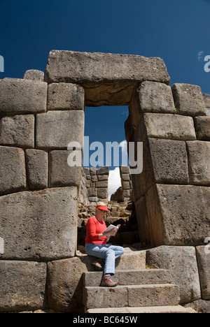 Peru, Sacsayhuaman, near Cuzco, an Inca fortification, tourist reading guide book Stock Photo
