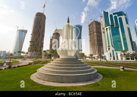 The Dallah coffee pot sculpture on the Corniche in Doha the capital of Qatar behind it are new high rise buildings being built Stock Photo