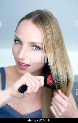 Young woman brushing her hair, portrait Stock Photo
