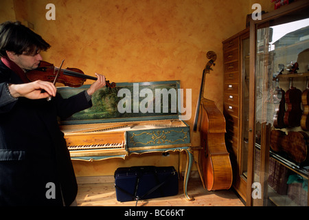 Italy, Lombardy, Cremona, violin maker's shop, man playing violin Stock Photo