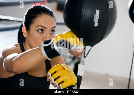 A female boxer training on a punching bag Stock Photo