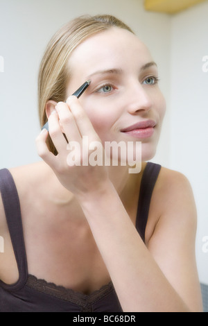 Young woman plucking eyebrows, close up Stock Photo