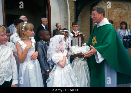 St Joseph's Church Roehampton Children & Priest Arms Outstretched Stock Photo