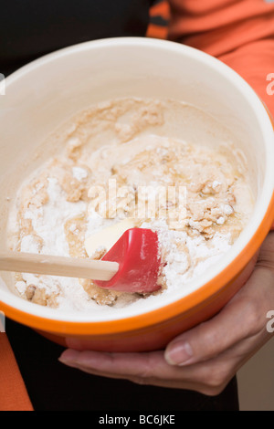 Woman stirring mixture in a baking bowl (close-up) - Stock Photo