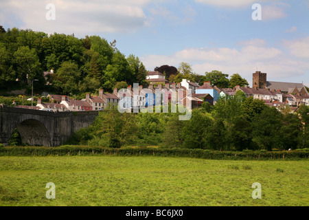 The River Towy flowing under a stone bridge below the hillside town of Llandeilo Stock Photo