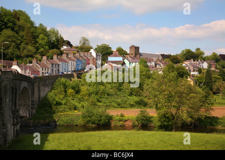 The River Towy flowing under a stone bridge below the hillside town of Llandeilo Stock Photo