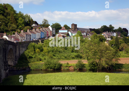 The River Towy flowing under a stone bridge below the hillside town of Llandeilo Stock Photo