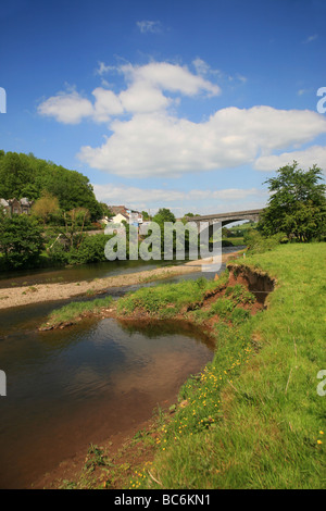 The River Towy flowing under a stone bridge below the hillside town of Llandeilo Stock Photo