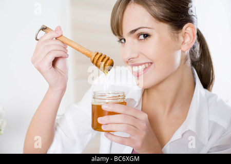 woman eating honey Stock Photo