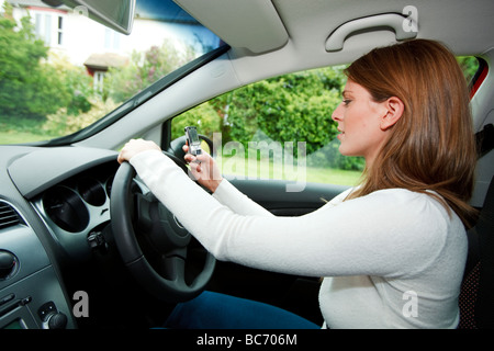 woman driving and texting at the same time Stock Photo