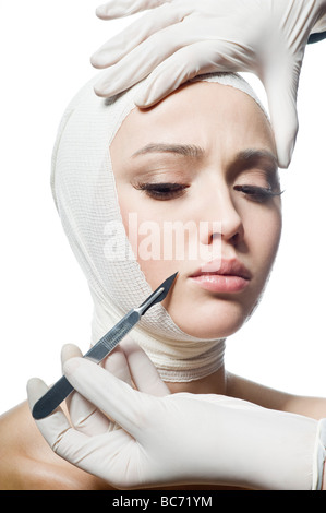 Hand holding a scalpel in front of face Stock Photo