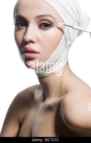 Hand holding a scalpel in front of face Stock Photo