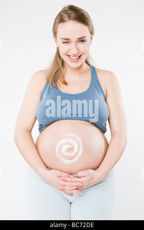 Pregnant woman creaming belly Stock Photo - Alamy