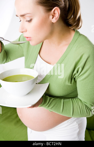 pregnant woman eating soup
