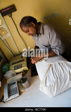 wrapping a parcel ready for posting in India Stock Photo