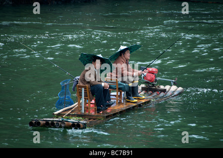 Two fishermen fishing from bamboo raft Li River Guangxi China Stock Photo