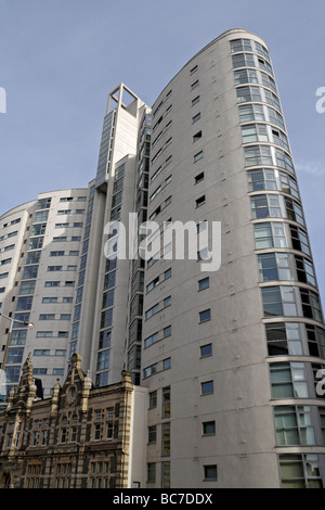 The Altolusso tower in Cardiff city centre Wales UK, above the facade of the old New College inner city living housing. Tall high rise tower block Stock Photo