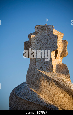 Moon on top of mosaic like chimney side lighted by sunset at rooftop of Casa Milà Barcelona Spain Stock Photo