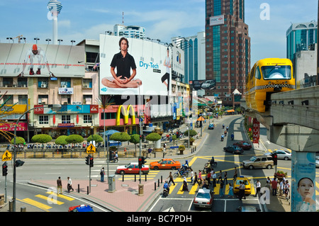 A monorail train rides above a major intersection in the Bukit Bintang shopping district of Kuala Lumpur, Malaysia, SE Asia. Transport; urban scene Stock Photo