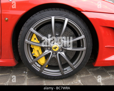The enormous ceramic ventilated disc brake in the front wheel of a Ferrari F430 scuderia Stock Photo