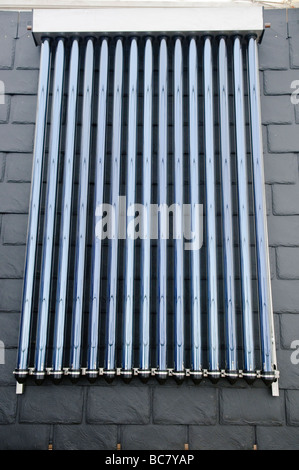 Heatpipe type solar water heater mounted on a slate roof Stock Photo