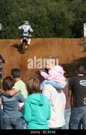 A little girl on her dad's shoulders at a Suffolk motocross Stock Photo