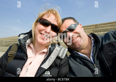 Happy couple smiling on a beach in England Stock Photo