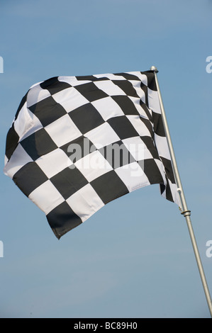 Black and white chequered flag flying on an English beach indicating no swimming in the area Stock Photo