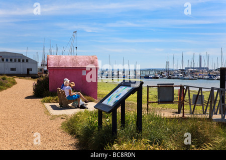 Three passengers wait for the ferry at Warsash, destination of Hamble-Le-Rice on the far bank of the River Hamble, Hampshire Uk Stock Photo