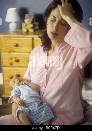 Mother suffering from postnatal depression holding her new baby boy Stock Photo