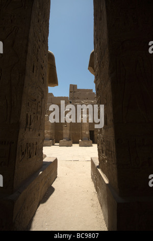 Statues glimpsed through a gap in the columns of the temple of Ramses III inside Karnak Temple, Luxor, Egypt Stock Photo