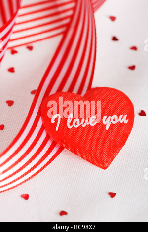 I Love You love heart with red and white striped ribbon Valentines day theme against white background Stock Photo