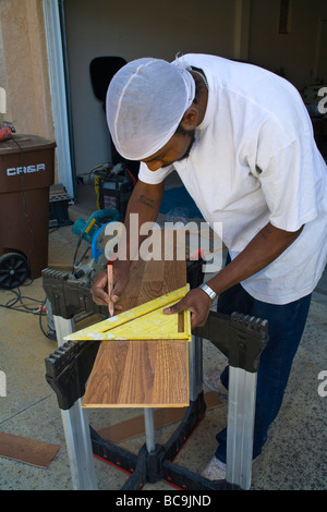 Man measures wood laminate for home flooring MR  © Myrleen Pearson Stock Photo