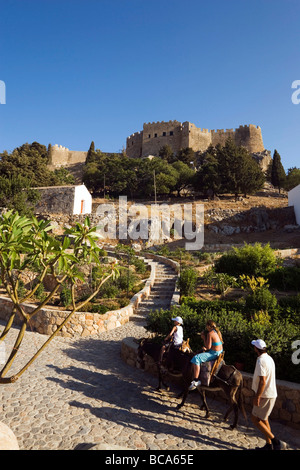 Tourists riding on donkeys to Acropolis, Lindos, Rhodes, Greece Stock Photo