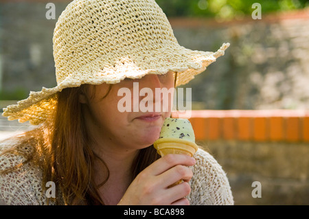 Young Woman In A Hat Eating An Ice Cream Stock Photo