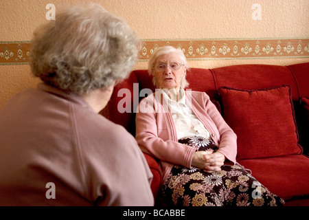 two elderly ladies at home having a conversation Stock Photo