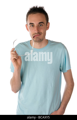 Young man holding eye glasses in mouth Stock Photo