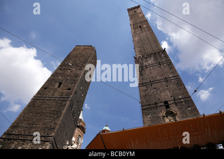 looking up at the two towers with the statue of st petronius by brunelli in piazza ravegnana bologna italy Stock Photo