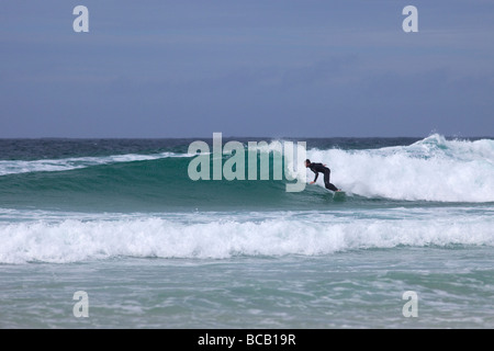 Surfing waves off Porthmeor beach in summer sun St Ives Cornwall England UK United Kingdom GB Great Britain British Isles Europe Stock Photo